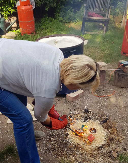 Caroline removing raku items from the kiln